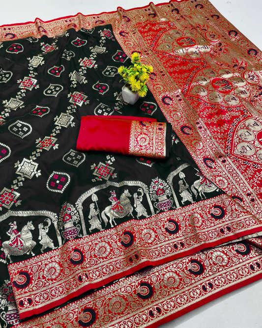 Black and red Banarasi silk saree with intricate gold zari embroidery, featuring traditional folk art motifs and a matching red and gold folded fabric piece.